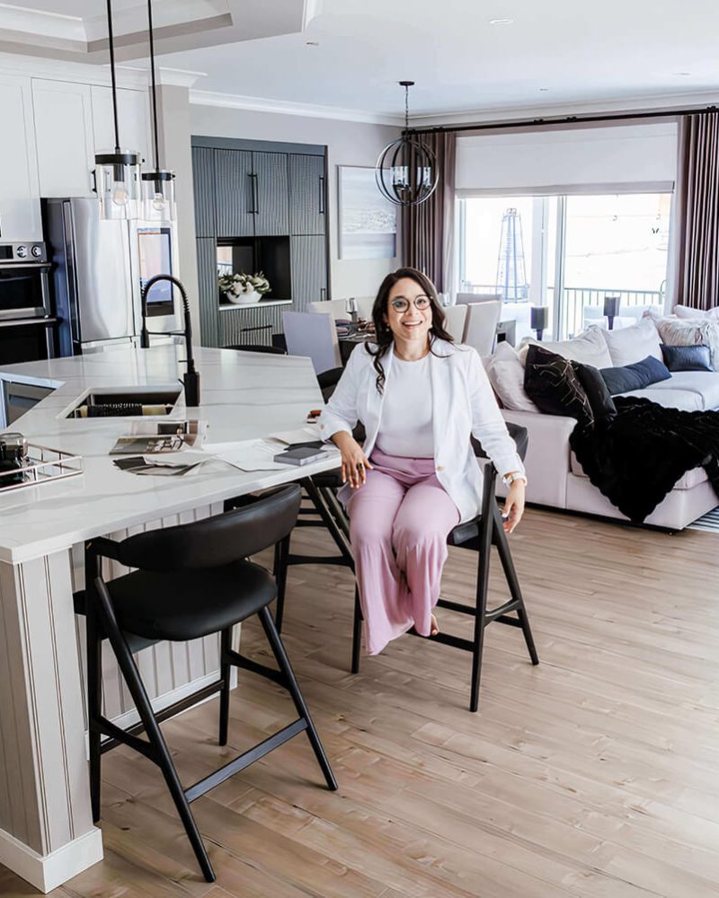 Julieta Diaz seated at a marble kitchen island in a finished open plan home