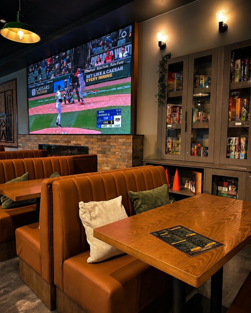 Leather booths beside a board game library at Cue's N Cushion