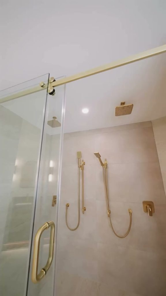 Glass shower with brushed brass fixtures and large-format tile in the Port Moody ensuite